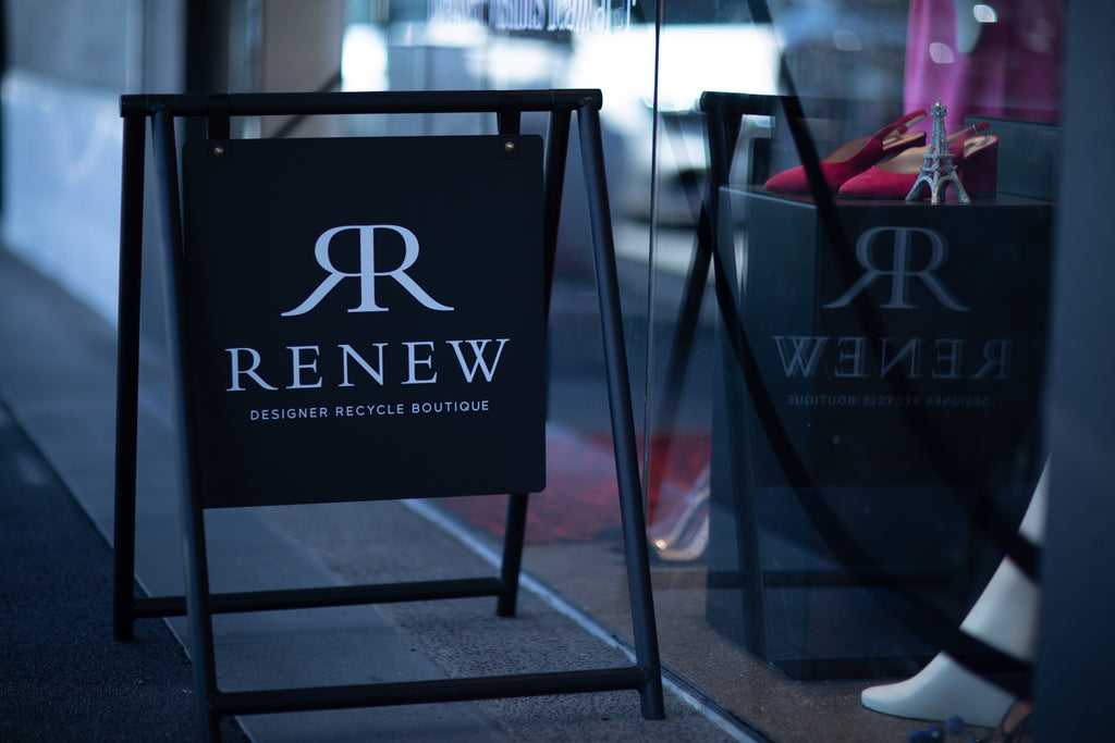 The 'Renew' store street sign reflecting in the shop window at 394 Remuera Road.